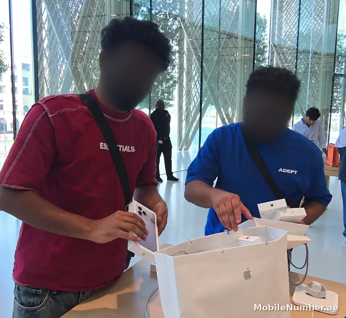 Two buyers with their iPhone 18 Pro purchases inside an Apple Store in Dubai on launch day